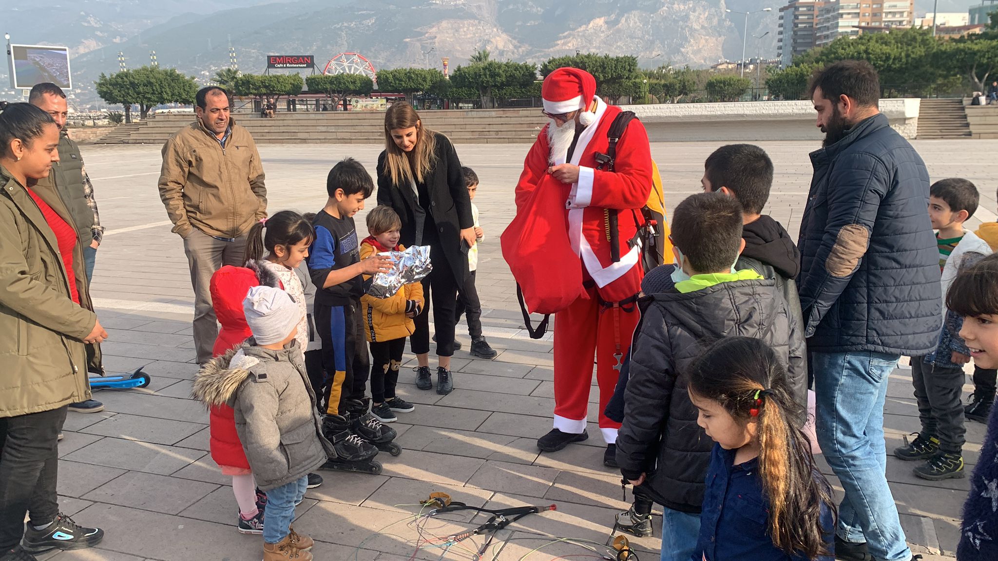 Noel Baba kostümüyle Amanoslar'dan yamaç paraşütüyle atlayıp çocuklara hediye dağıttı