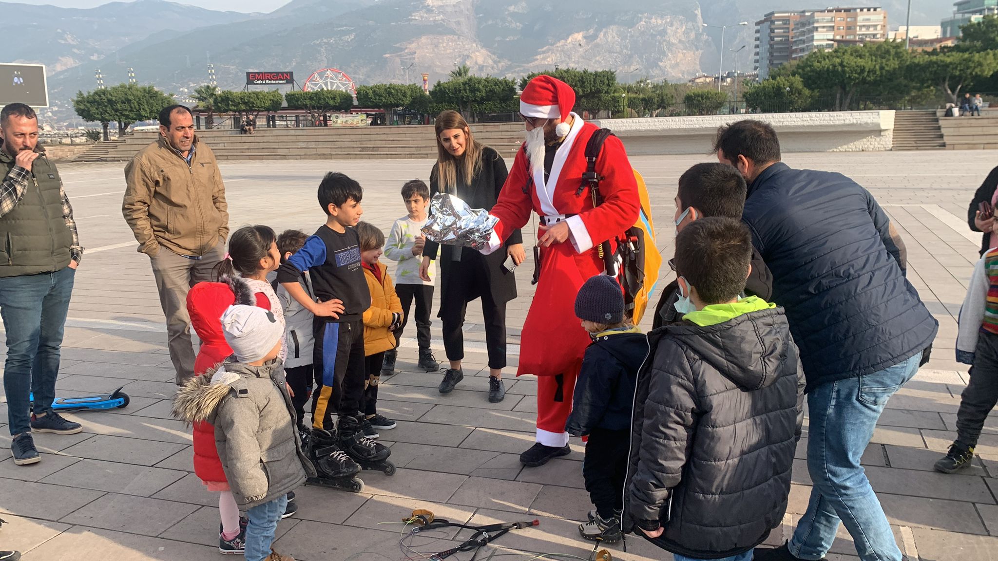 Noel Baba kostümüyle Amanoslar'dan yamaç paraşütüyle atlayıp çocuklara hediye dağıttı