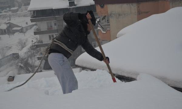 Bellerine halat bağlayıp, çatıları kardan temizliyorlar