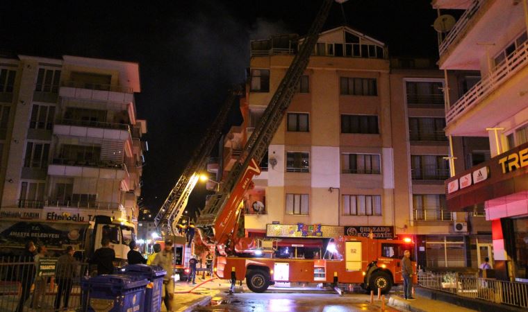 Karşı apartmandaki yangına balkondan hortumla müdahale etti