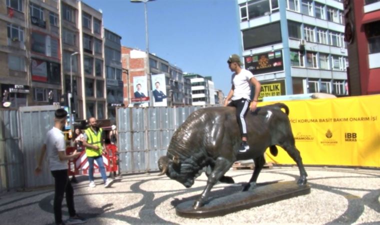 Kadıköy'de bakıma alınan Boğa Heykeli'nin üzerine çıkıp fotoğraf çektirdi (25 Nisan 2022)