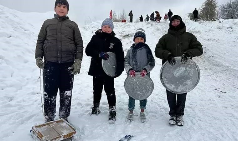 Çocuklar, fırın tepsisi, leğen, poşet ve kızakla kaydı