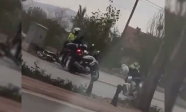 Polis, seyir halindeki motor sürücüsüne kaskla vururken görüntülendi