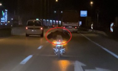 Plakasını kapattığı motosikletinin üzerine yüzüstü yatıp, trafikte ilerledi