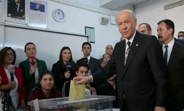 Bahçeli oy kullanırken bir genç arkasından kalp işareti yaptı