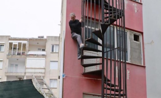 Yarım kalan yangın merdiveninde mahsur kaldı